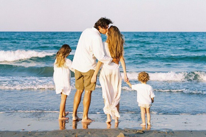 A family of four on a beach with waves in the background. 2