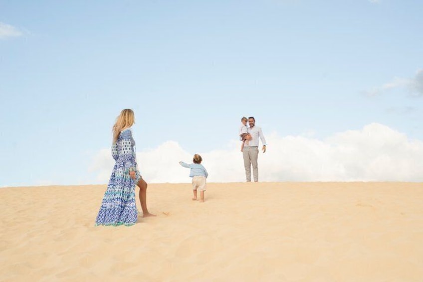 A family on a sandy dune with a clear sky. 4