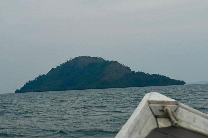 A boat on calm water with a small island in the distance. 2