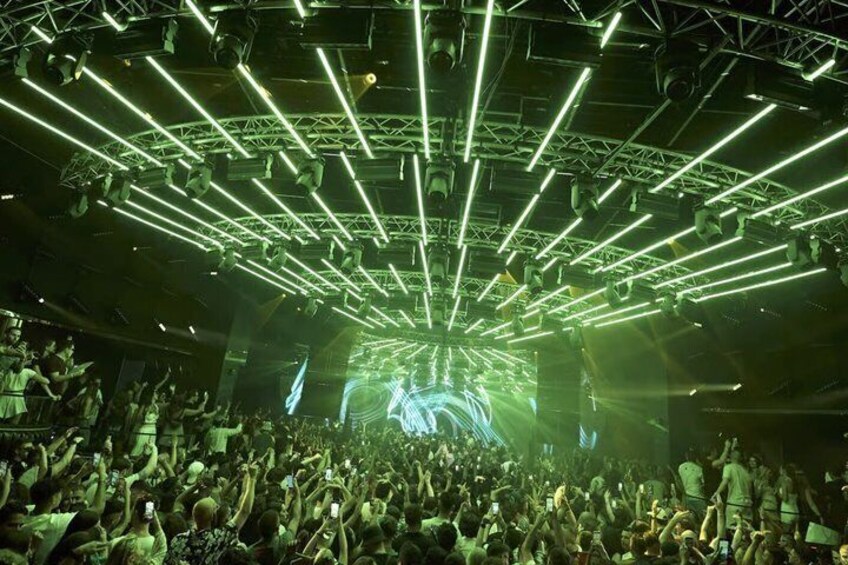 A concert with a green-lit stage and a crowd of people. 4