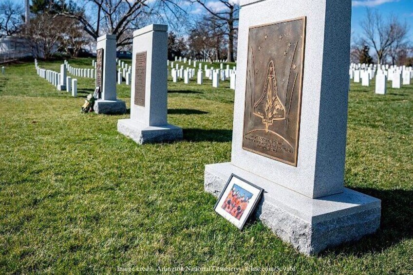 Un cimitero con lapidi, una delle quali presenta l'emblema di uno space shuttle. 4
