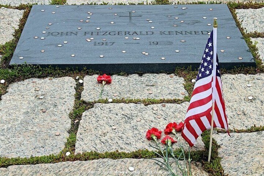 Una lapide con una bandiera americana e fiori rossi. 5