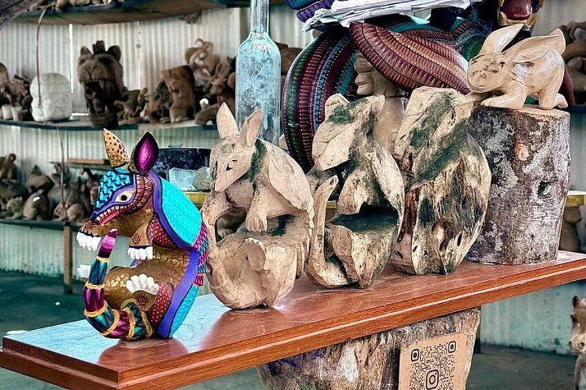 Una estantería de madera con diversas esculturas de animales, incluyendo un dragón colorido y varias figuras de ciervos. 5