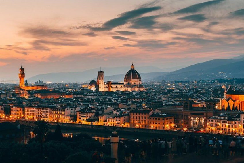 A cityscape at dusk with prominent domed buildings and a tower. 2