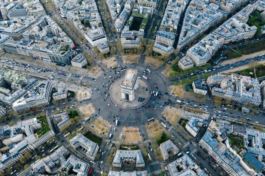 An aerial view of a city with a central roundabout surrounded by buildings and roads. 2
