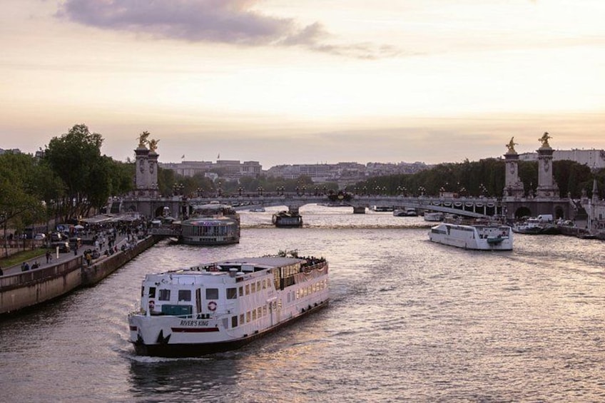 A river with boats, a bridge, and a cityscape with buildings and trees. 5