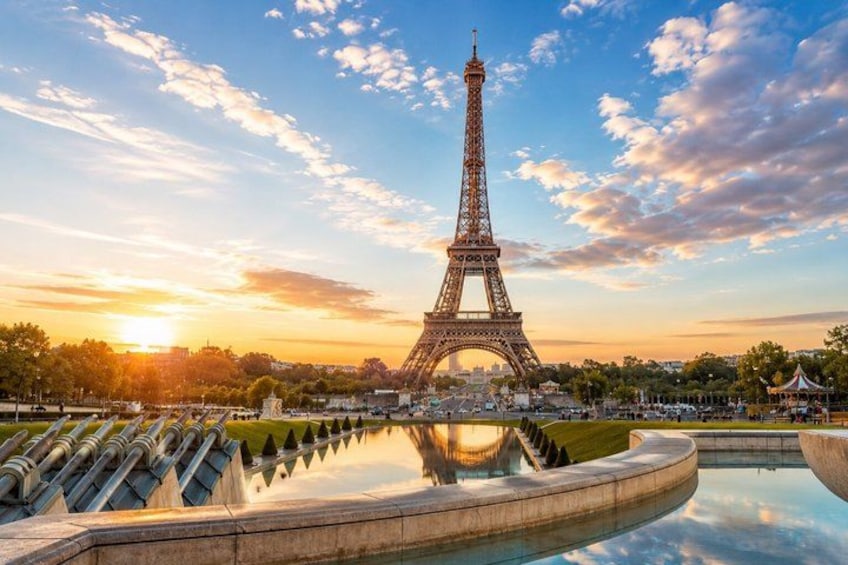 The Eiffel Tower at sunset with reflections in a water feature. 1