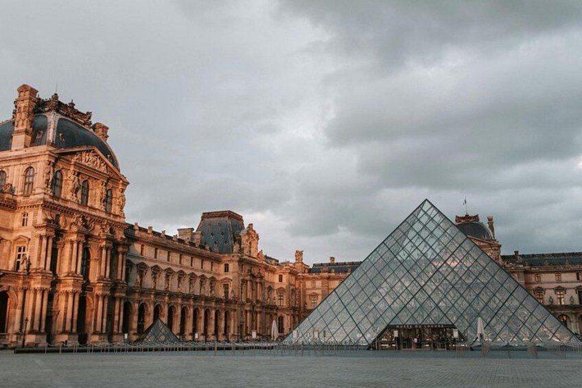 The Louvre Museum with the iconic glass pyramid in the foreground and classical architecture in the background. 2