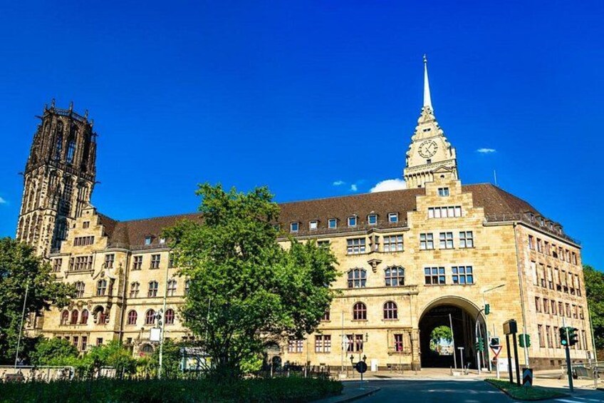 A historic building with a clock tower and a large arched entrance. 1
