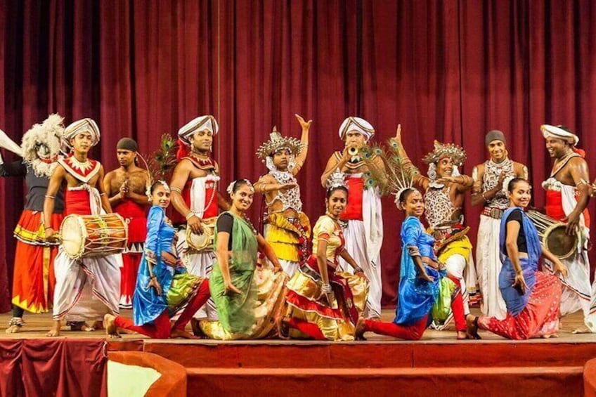 Een groep artiesten in traditionele kostuums op een podium. 2