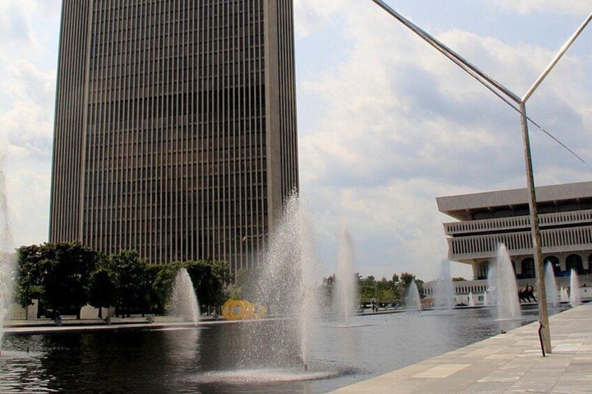 Een hoog gebouw, een fontein en een modern bouwwerk met een uniek ontwerp. 5