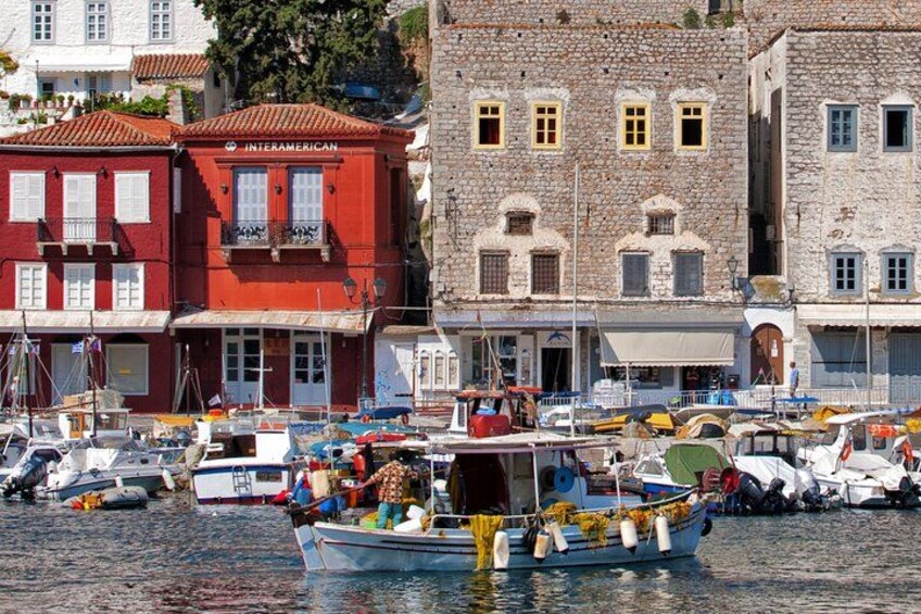 A harbor with boats docked, a red building labeled 'INTERAMERICAN,' and a stone building with multiple windows. 5