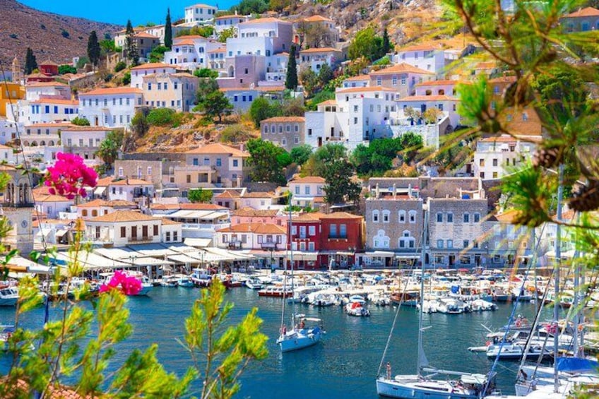 A coastal town with buildings, boats, and a clear blue sea. 1