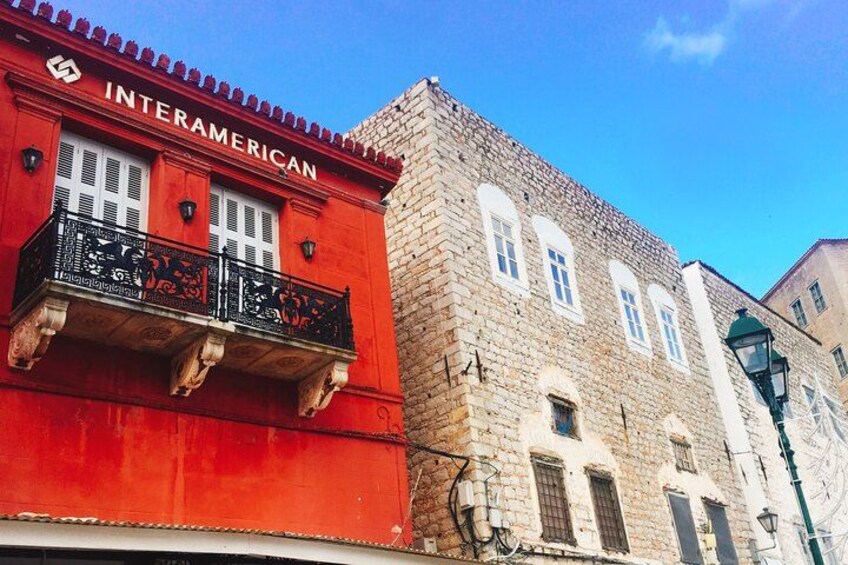 A red building with a sign that reads 'INTERAMERICAN' and a stone building with multiple windows. 3