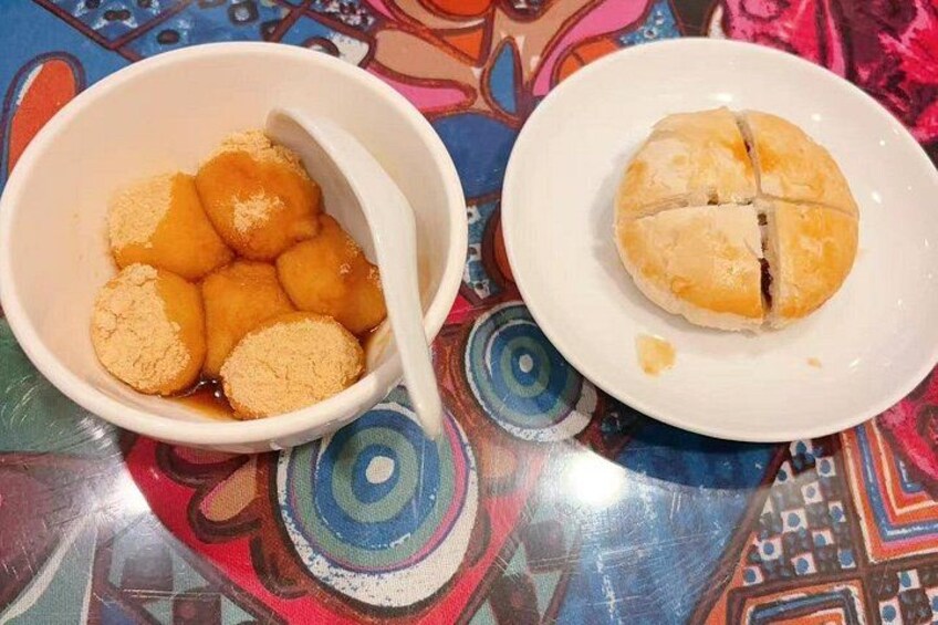 A bowl of doughnuts and a plate with a cut-open doughnut. 5