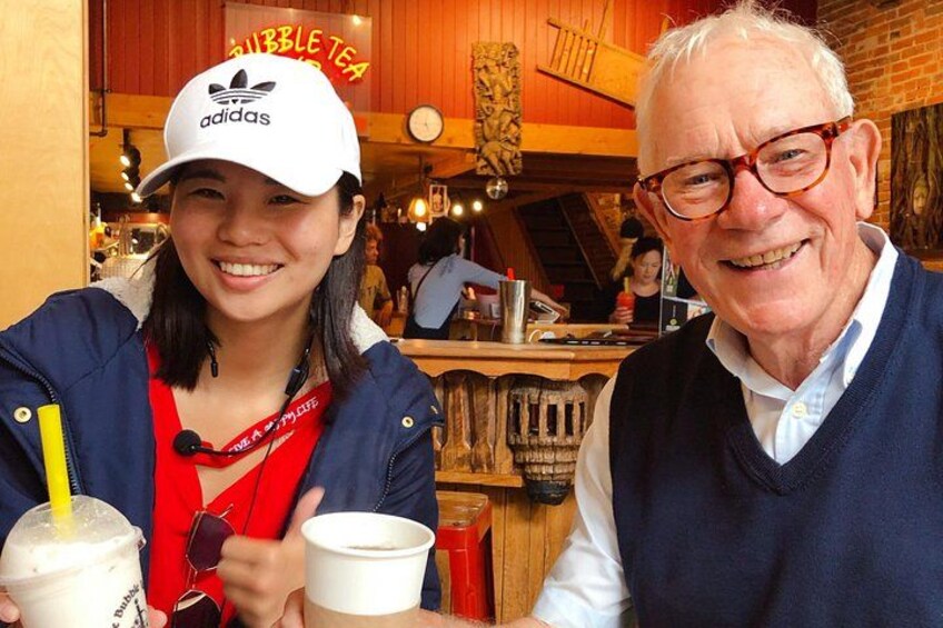A person wearing a white Adidas cap and a red shirt holding a drink with a straw. 1