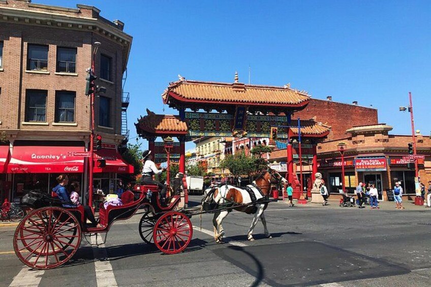 A street with a traditional Asian-style building, a horse-drawn carriage, and a red awning with the name 'Quonset.' 4