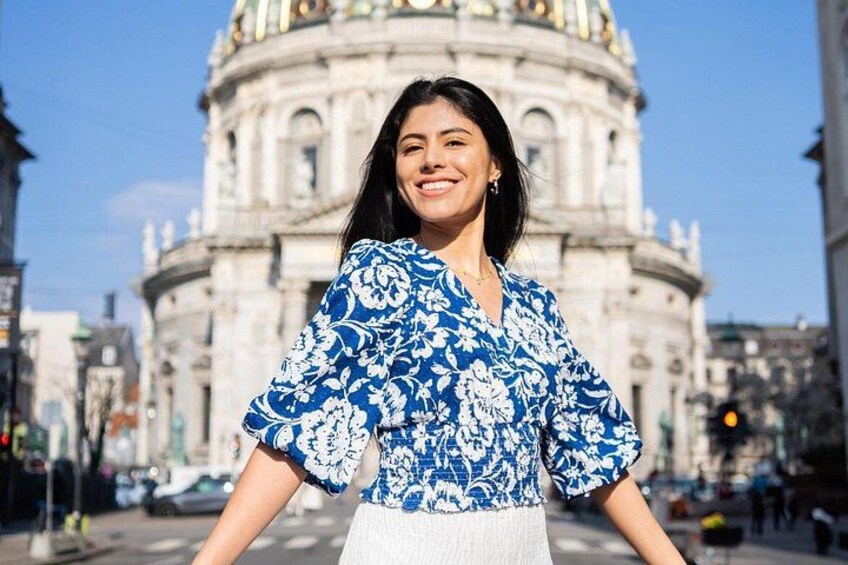 A person in front of a large, historic building with intricate architecture. 2
