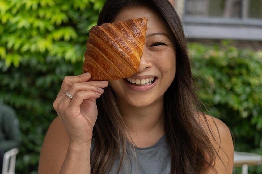 A person holding a croissant. 3