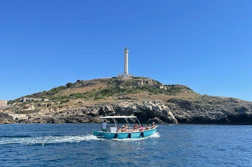 Ein Boot auf dem Wasser, im Hintergrund ein Leuchtturm auf einer felsigen Insel. 3