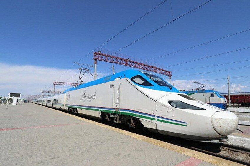 A high-speed train at a station with overhead electrical lines. 2