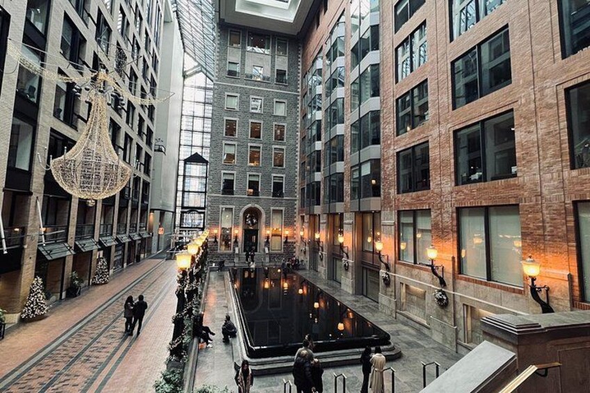 A modern building with a central courtyard, large windows, and decorative lighting. 1