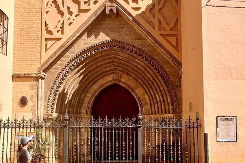 A Gothic-style archway with intricate carvings and a red door. 4