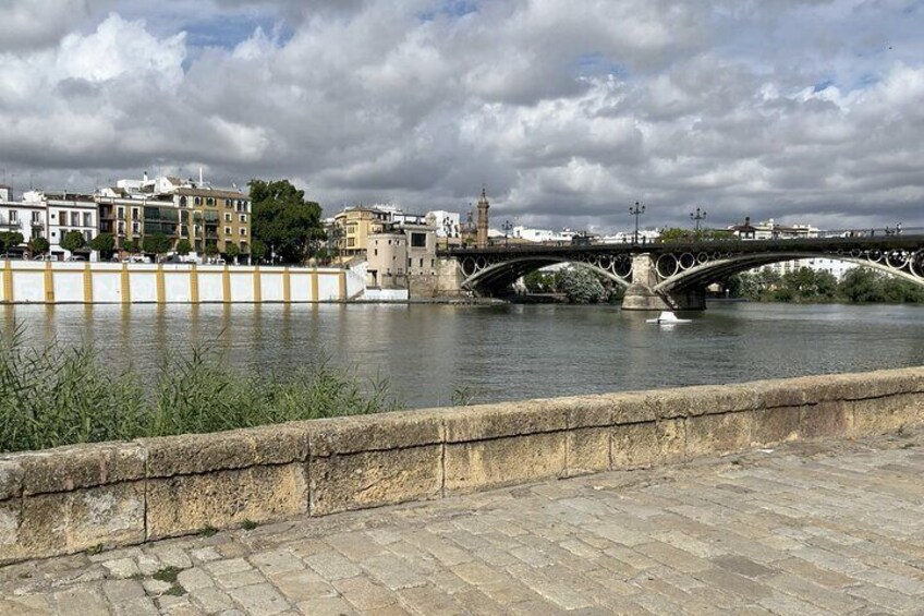 A stone bridge over a river with buildings in the background. 2