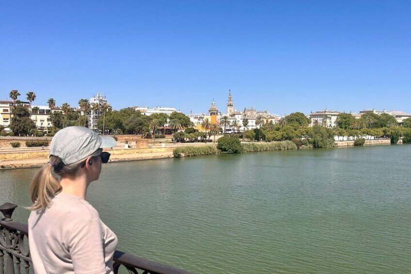 A person overlooking a river with buildings and a tower in the background. 5
