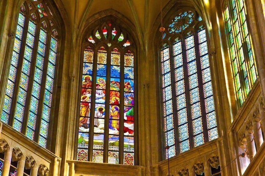 A cathedral interior with large stained glass windows and Gothic architecture. 5