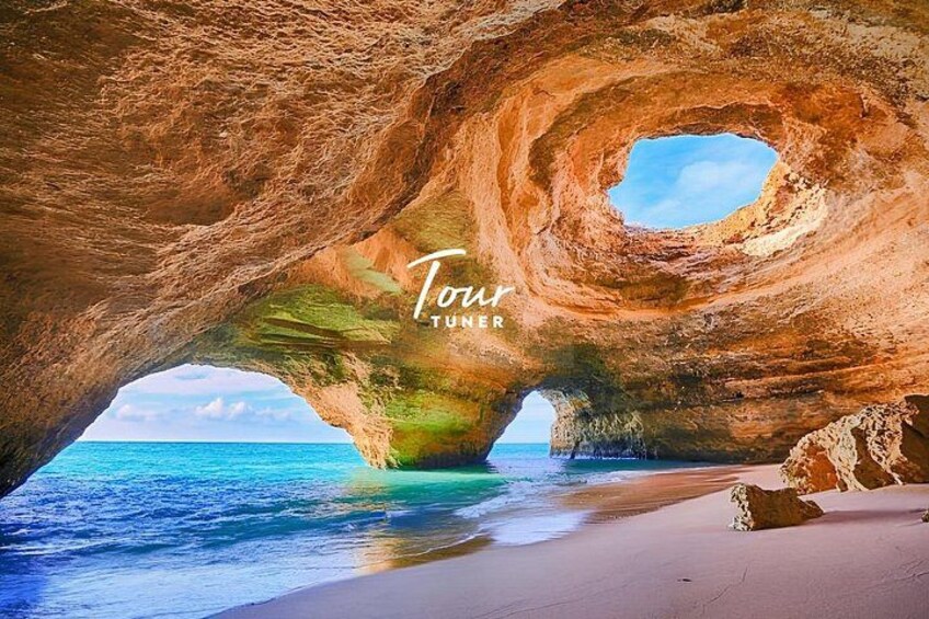 A natural rock formation with a hole, a beach, and the ocean. 1