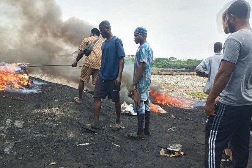 People standing near a fire with smoke in the background. 1