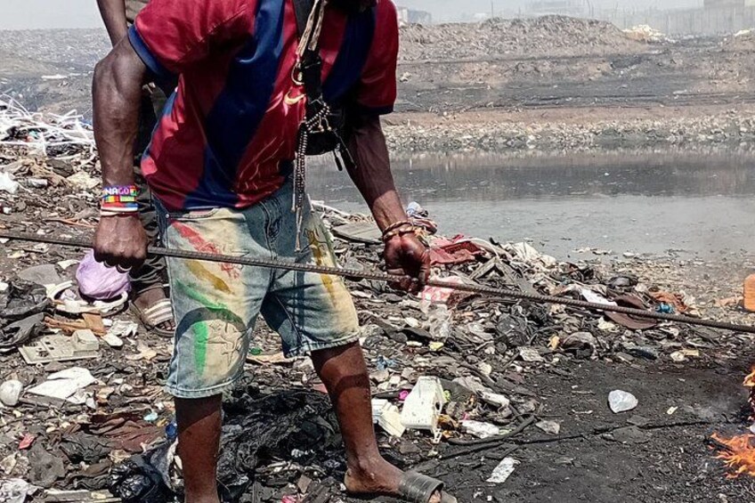 A person working with a long pole amidst a large amount of debris and trash. 3