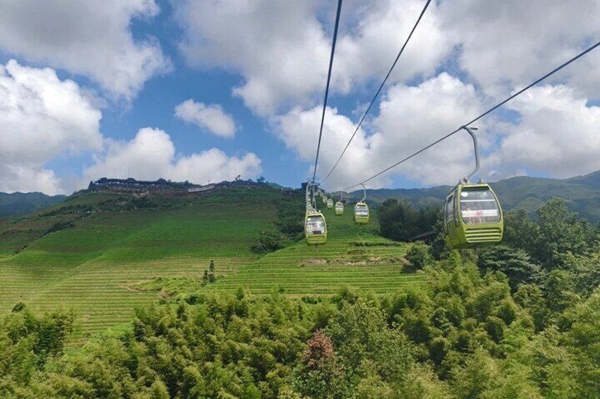 A cable car system in a hilly landscape with green fields and trees. 4