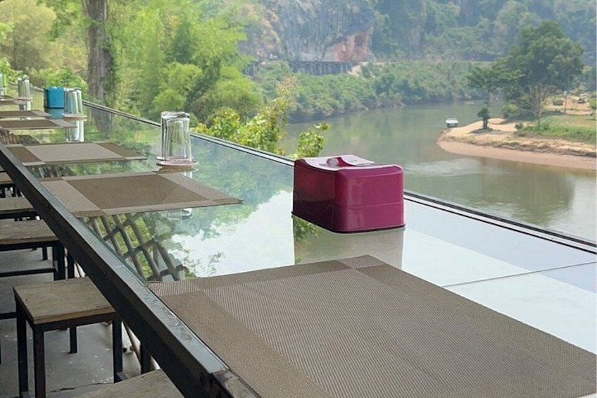 A glass table with chairs overlooking a river. 2