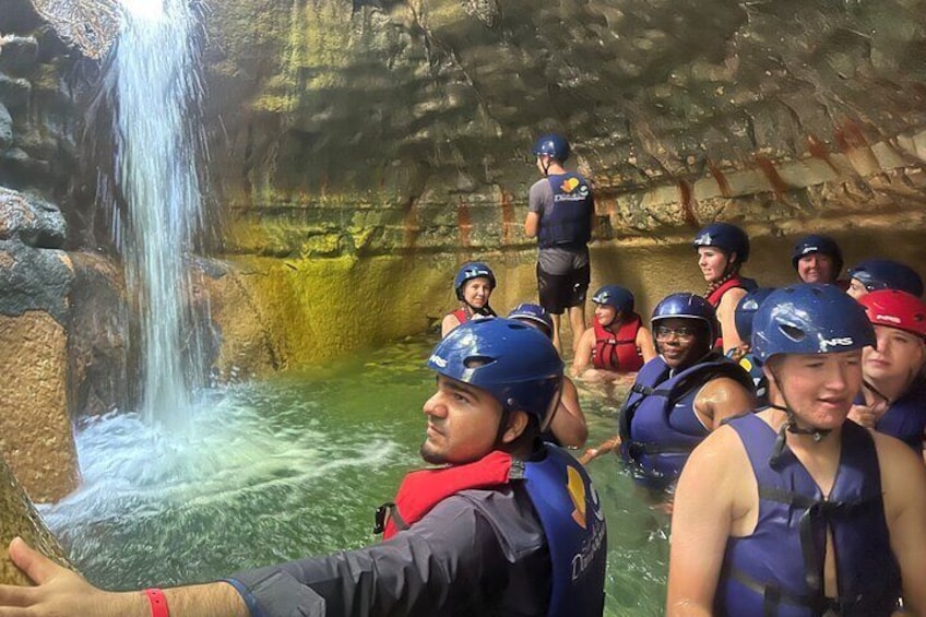 A group of people in a cave with a waterfall. 2