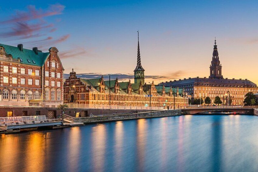 A riverside cityscape with historic buildings and a prominent tower. 4