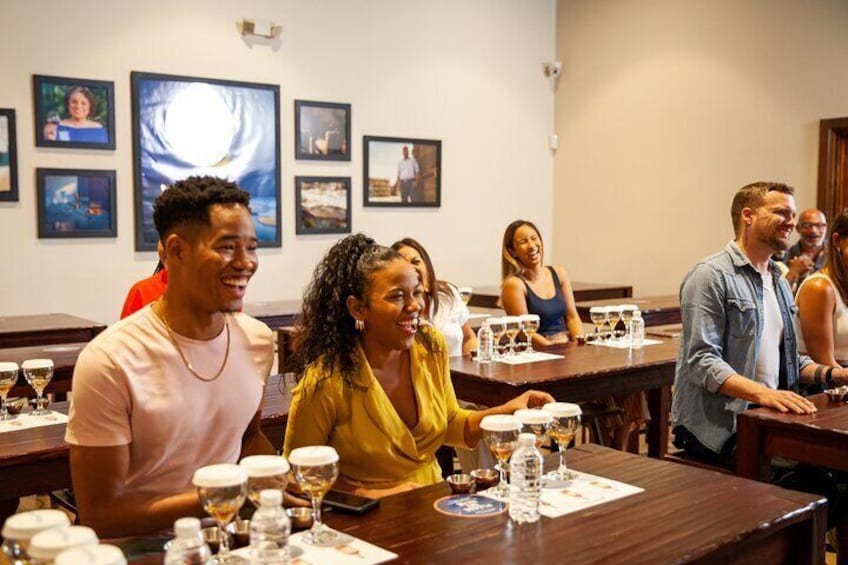A group of people seated at tables in a restaurant with wine glasses and plates. 5