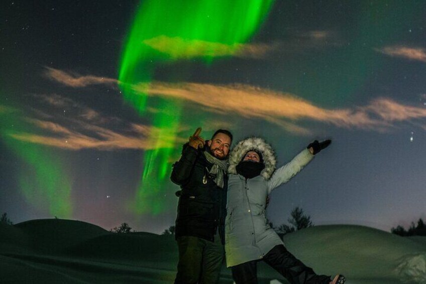 Two people posing under the aurora borealis. 1