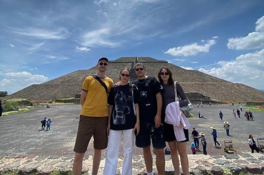 Un groupe de personnes se tient devant une grande colline, sous un ciel dégagé. 4