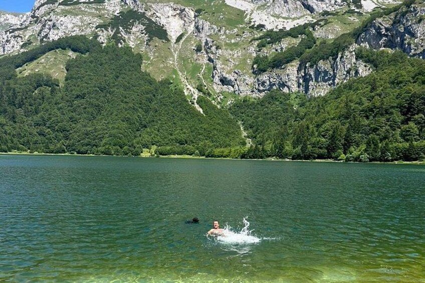A person swimming in a lake with mountains in the background. 5