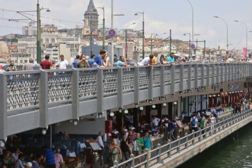 A crowded pedestrian bridge with people walking and standing. 3