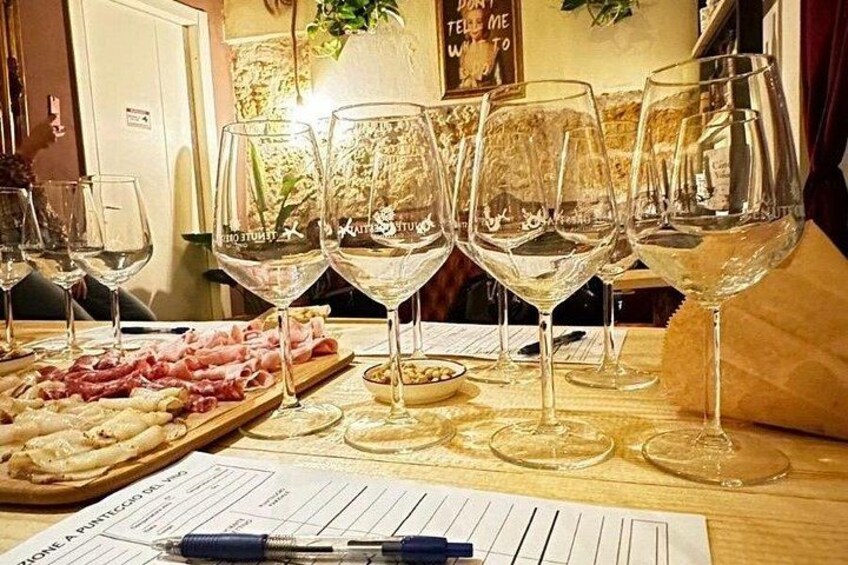 A table with wine glasses and a charcuterie board. 4