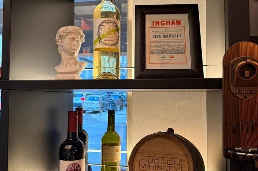 A bar shelf with bottles, a framed certificate, and a wooden barrel. 2