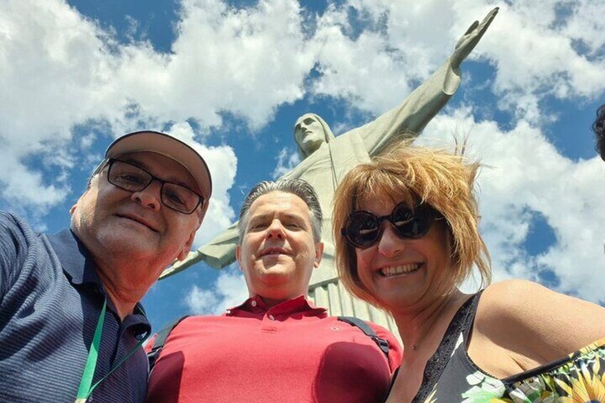 Trois personnes se tiennent devant une statue. 1