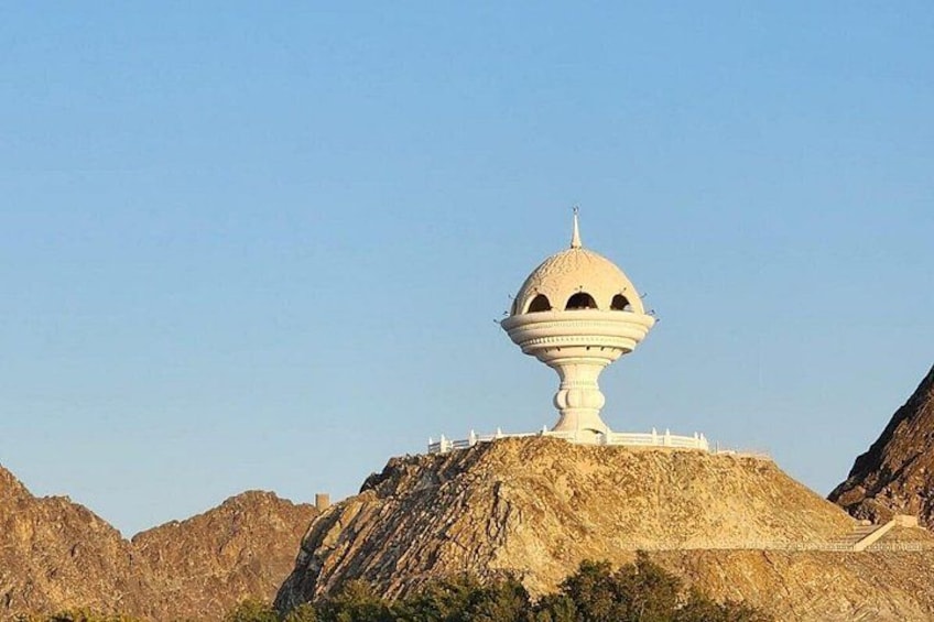 Una estructura blanca en forma de cúpula sobre una colina, con terreno rocoso al fondo. 5