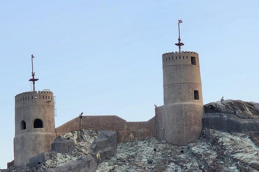 Una fortaleza histórica con dos torres destacadas, una con veleta y la otra con bandera. 4