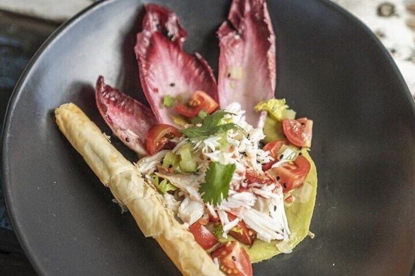 Une assiette contenant un wrap, des tomates en tranches, du fromage râpé et une garniture. 3