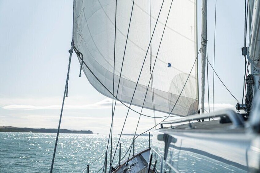 Un voilier avec une grande voile sur une mer calme. 1