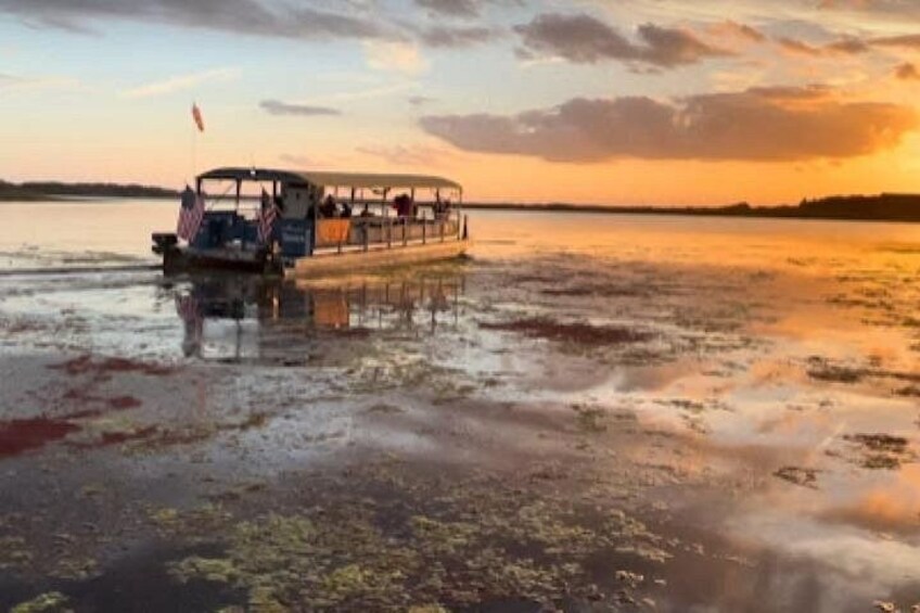 A boat on a body of water during sunset. 1
